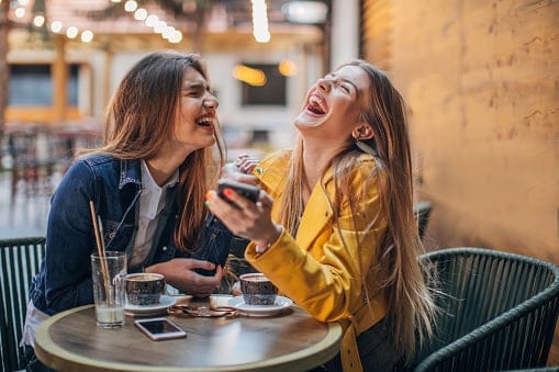 Young ladies gossiping in cafe.