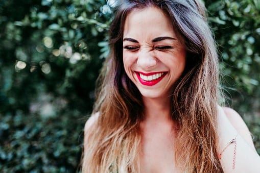 Young woman smiling outside.