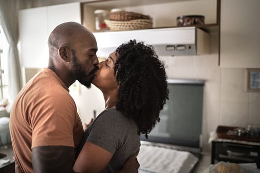 Happy couple dancing in kitchen.