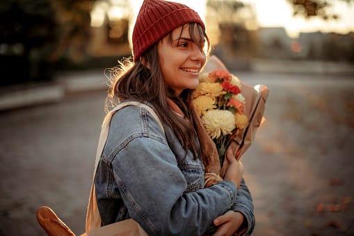 eenage women walking with flowers through city