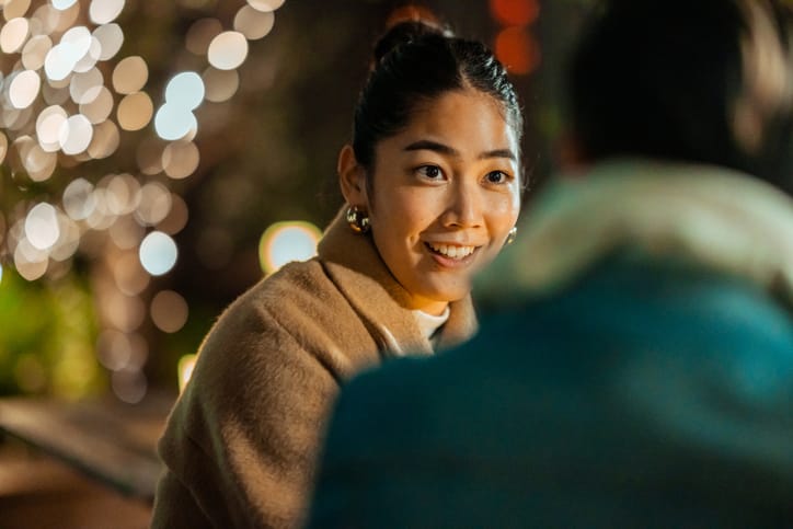 smiling woman flirting with man at night
