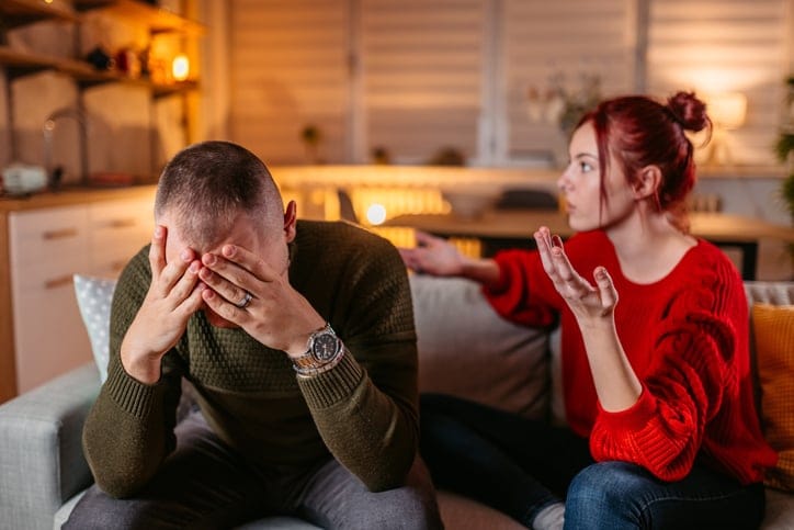 couple arguing on sofa in living room