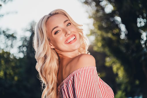 Profile photo of satisfied glad young lady toothy beaming smile look camera enjoy free time outside.