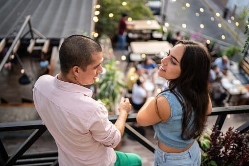 couple flirting at rooftop party