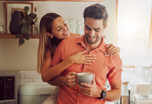 Happy, in love and carefree couple embracing, bonding and being affectionate at home together. Young boyfriend and girlfriend relaxing, talking, being playing and enjoying their relationship