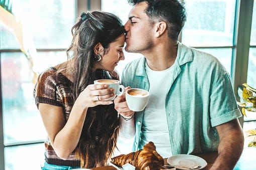 Happy couple enjoying breakfast and drinking coffee.