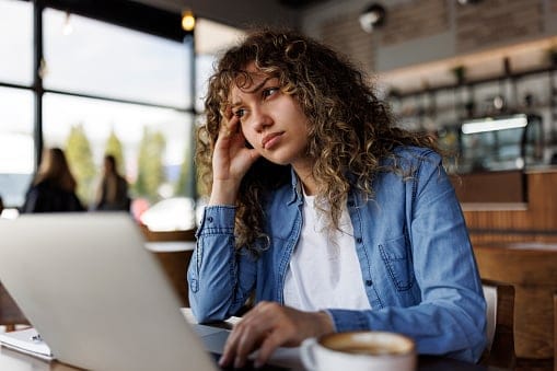 tired woman working at laptop