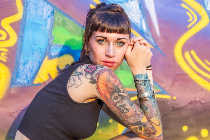 woman with tattoos looking outside