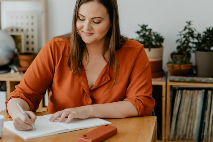 smiling woman writing in journal