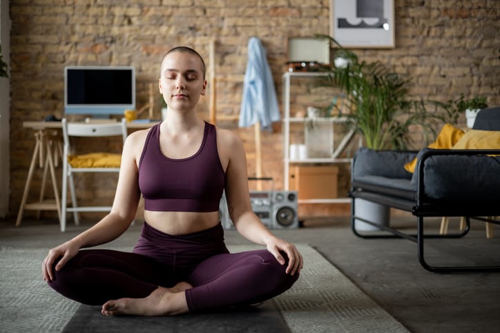 woman meditating quietly in apartment