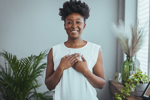 Smiling woman with her hands on her heart.