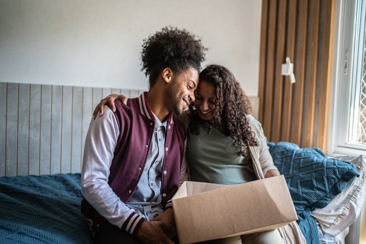 Mother helping son pack to move out from parent's home.