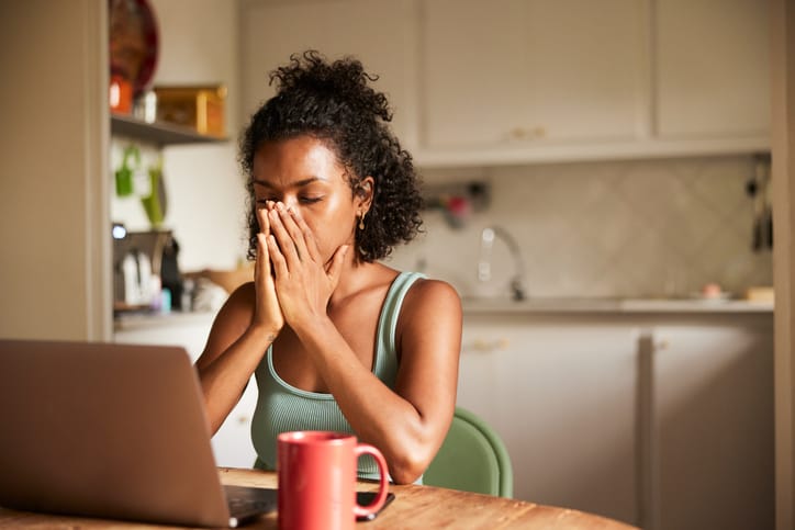 stressed woman sitting at kitchen table