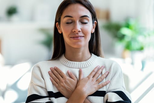 Woman doing stretches while relaxing on sofa at home.