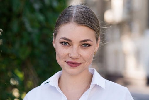 A close-up portrait of a young and attractive Caucasian woman in casual clothes while walking around the city. The concept of fashion, style, youth and lifestyle.