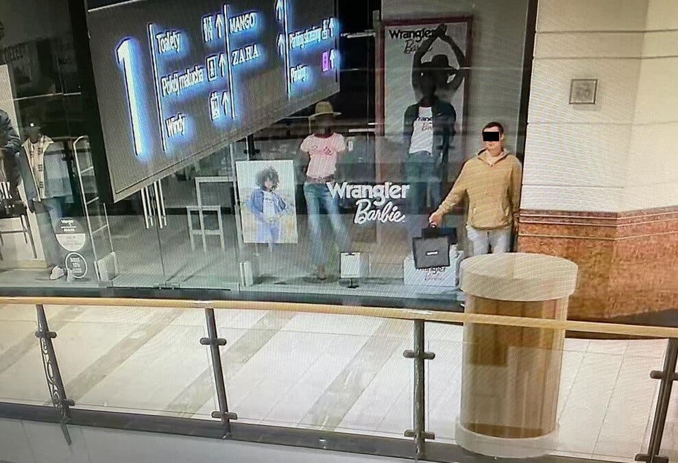 man posing as mannequin polish department store