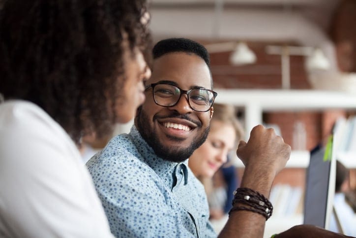 male colleague smiling at female colleague