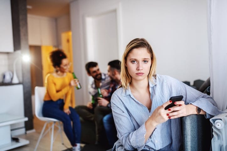 unhappy woman away from colleagues