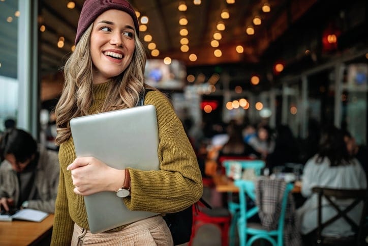 Smiling millennial woman at coffee shop.