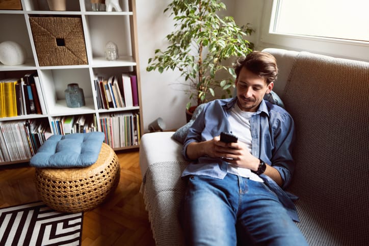 guy texting on couch