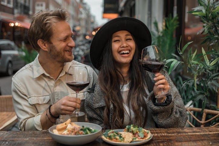 Couple on date drinking wine outdoors.
