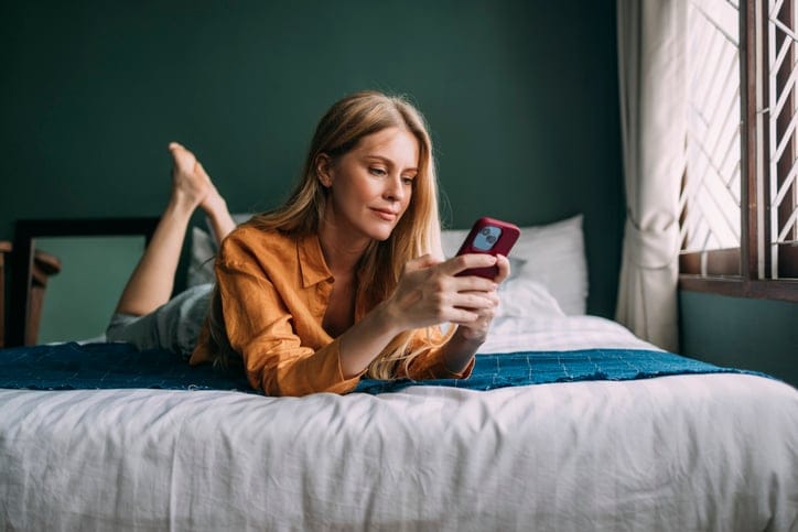 Woman texting in bed.
