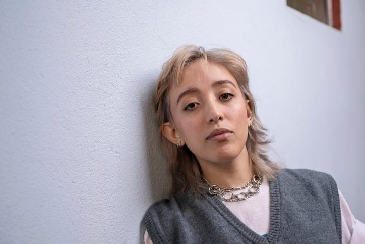 serious woman standing against wall