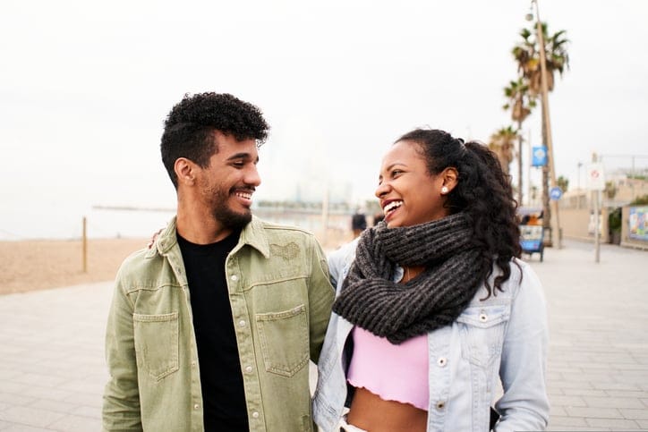 smiley couple walking on boardwalk