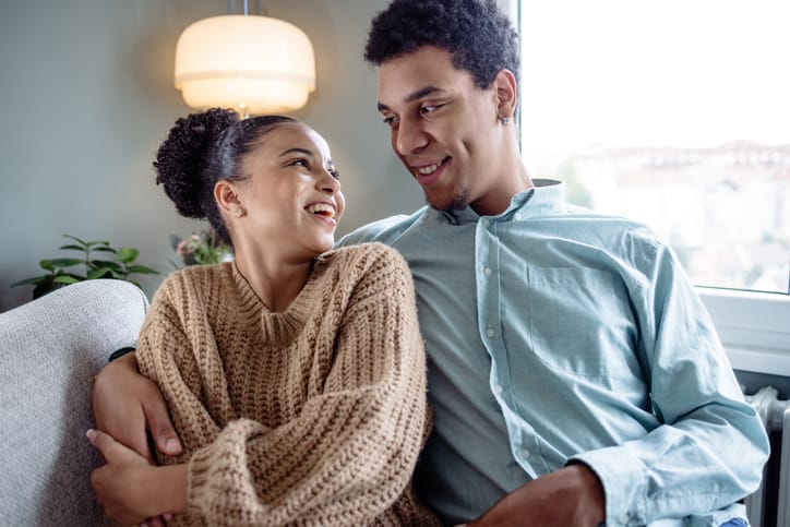 smiling couple sitting on couch together