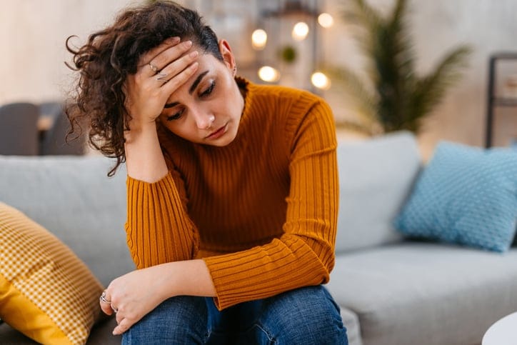 upset millennial woman on couch