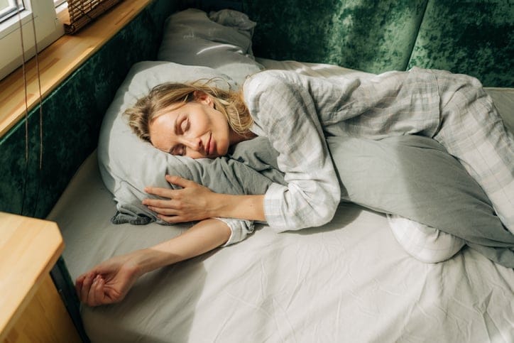 smiling woman sleeping in bed