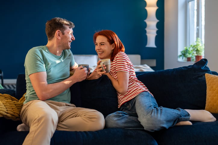 smiling couple chatting on sofa