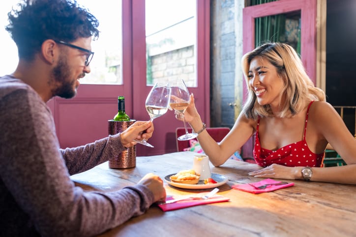 couple cheersing wine glasses date