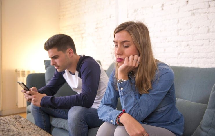 boyfriend ignoring girlfriend on couch