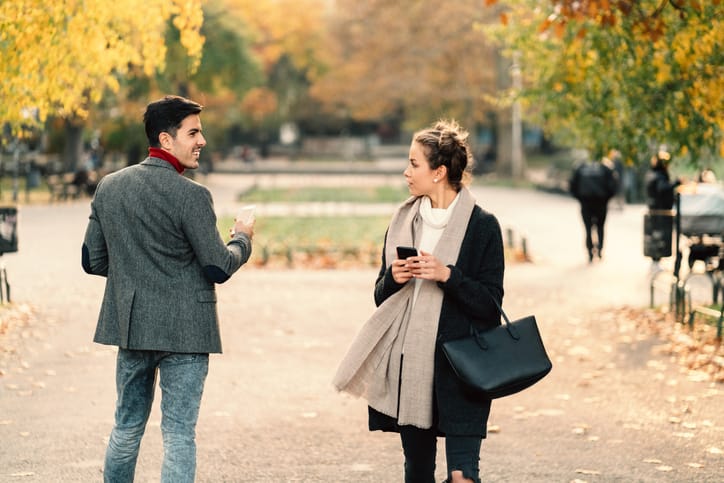 Young man staring beautiful woman while walking outside