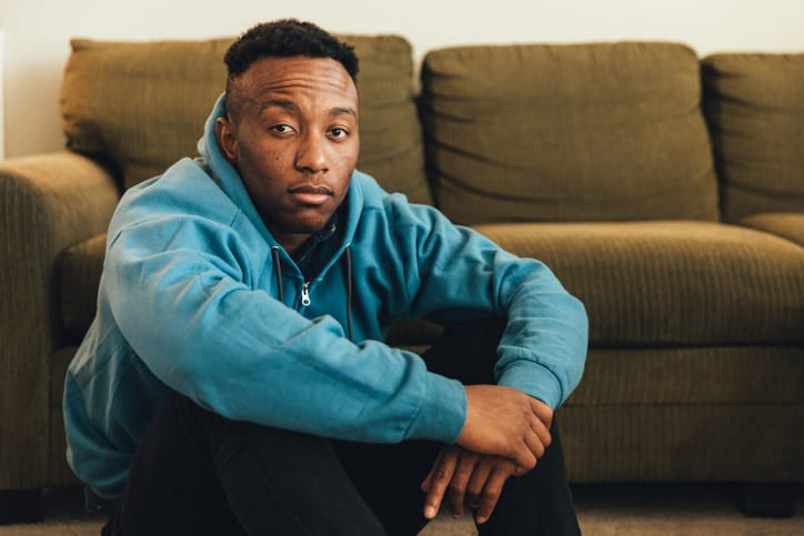 millennial guy sitting in living room