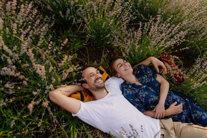 couple lying in field of flowers