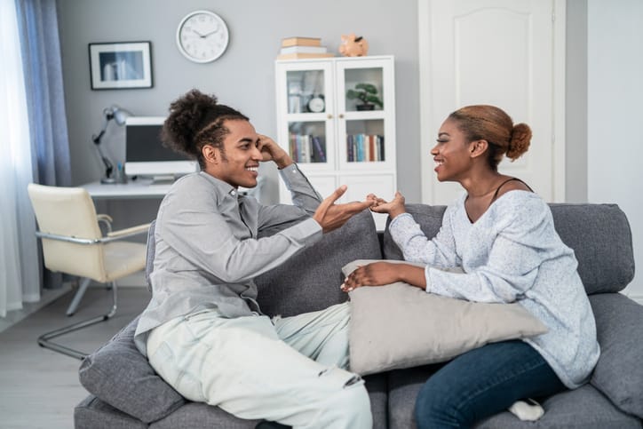 man and woman having serious conversation on couch
