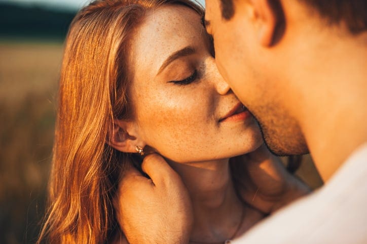 Romantic kiss close-up outdoors.