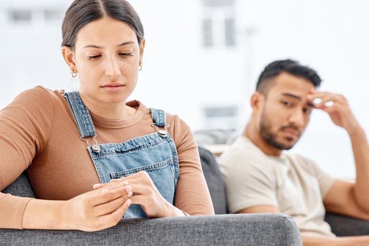 woman taking off wedding ring with man
