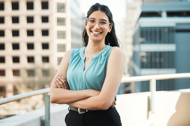 smiling woman with arms crossed on rooftop