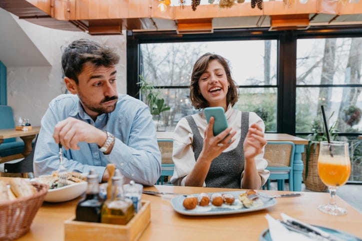 woman on phone at breakfast table