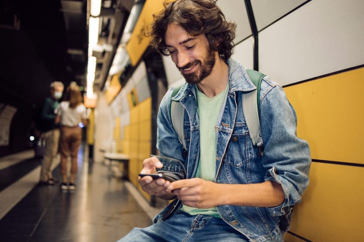 guy texting at subway station