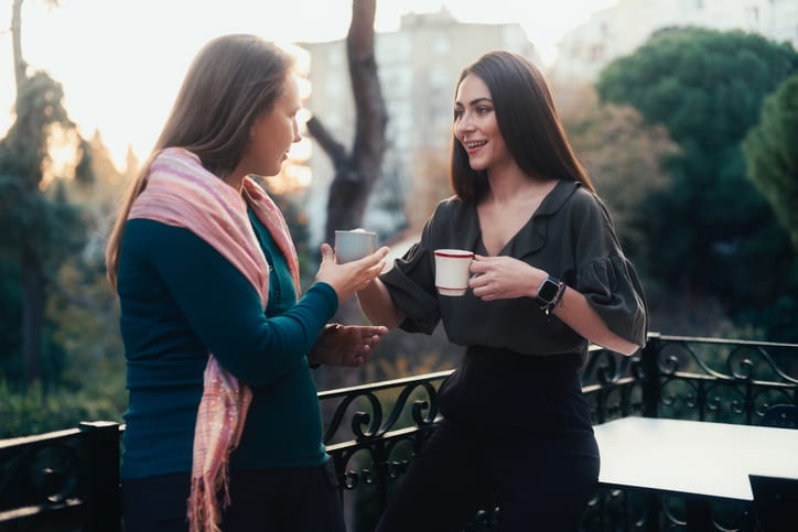 Women having coffee and talking on the balcony