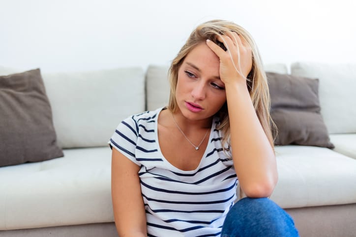 sad blonde woman in living room