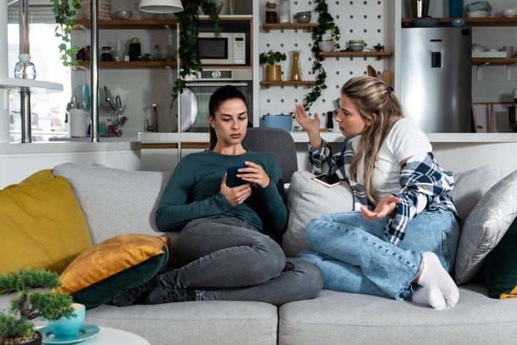 two friends arguing on couch