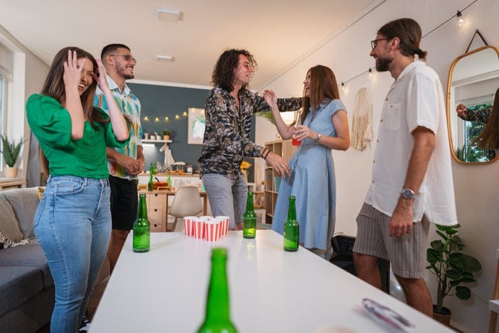friends playing beer pong at party