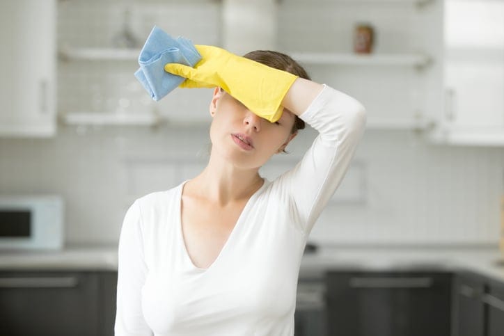 A woman feels tired out from house cleaning.