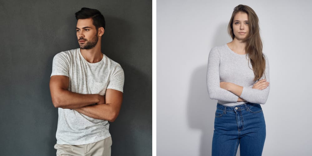 man standing up and woman standing alone, both have arms crossed