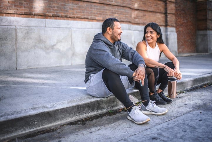 male and female friend chatting on steps